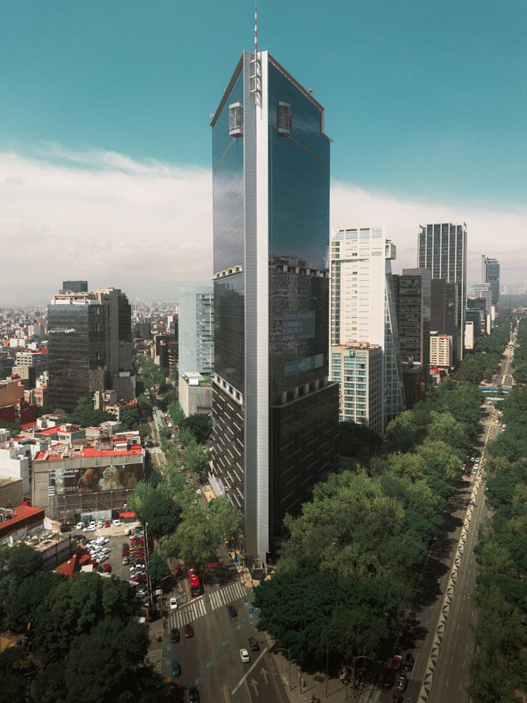 Aerial view of a towering skyscraper on Reforma Avenue in Mexico City with surrounding urban landscape.